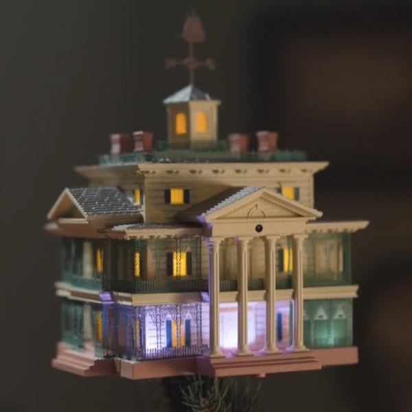 A Keepsake Ornament tree topper in the shape of the mansion from Disney The Haunted Mansion theme park attraction.